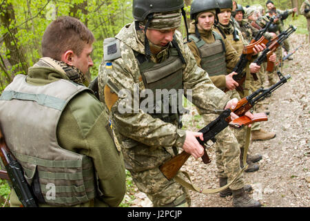 Eine ukrainische Soldaten und Student an der Yavoriv GÜZ Beobachter Controller Trainer Akademie stellt sicher, dass andere Studenten Waffen klar sind, nachdem ein situational Training trainieren Sie im CTC International Peacekeeping und Security Center in der Nähe von Yavoriv, Ukraine, am 20. April.   Studenten an der Akademie wechselten als ÜLG während der Trainings-Bahnen und wurden betreut von ukrainischen und US-Soldaten, Joint Multinational Training Group - Ukraine zugewiesen. JMTG-U-Mission ist zu helfen, errichtet die CTC-Fähigkeiten und Professionalität innerhalb der ukrainischen militärischen fördern. (Foto: Sg Stockfoto