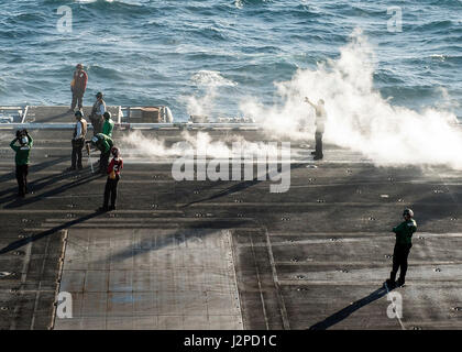 170420-N-JC445-149 arabischen Golf (20. April 2017) Segler signalisieren eines Flugzeugs auf dem Flugdeck des Flugzeugträgers USS George H.W. Bush (CVN-77). Das Schiff wird in den USA bereitgestellt 5. Flotte Bereich der Maßnahmen zur Erhöhung der Sicherheit im Seeverkehr Operationen, Verbündete und Partner zu beruhigen, und die Freiheit der Schifffahrt und den freien Fluss des Handels in der Region zu erhalten. (Foto: U.S. Navy Mass Communication Specialist 3. Klasse Mario Coto/freigegeben) Stockfoto