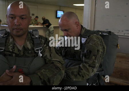 U.S. Army CPT. Loren Teillon, Recht, Kommandant der 982nd Combat Camera Company, prüft ein Fallschirm-Geschirr, US Army Spc. Rafael DiCristina, links, auch zugewiesen, um die 982nd Combat Camera Company angehören, während Fallschirm Ausbildung Operationen an Papst Army Airfield befindet sich in Fort Bragg, NC, 21. April 2017. US-Soldaten, die 982nd Combat Camera Company, 824th Quartermaster Company und der United States Army Civil Affairs und Psychological Operations Command zugewiesen bereiteten für einen Fallschirmsprung aus einem c-130 Hercules Flugzeuge auf Sizilien-Drop-Zone befindet sich in Fort B Stockfoto