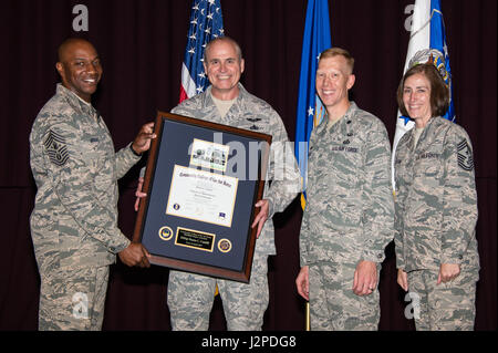 Chief Master Sgt. der Luftwaffe Kaleth O. Wright präsentiert Senior Master Sergeant Duane Caudill, 302. Pflegegruppe Karriereberater mit den 500. 000sten Volkshochschule der Luftwaffe Grad, 21. April 2017, Maxwell Air Force Base in Alabama Die Volkshochschule der Luftwaffe Kommandant, Oberstleutnant Nathan J. Leap und Chief Master Sgt. Vicki Robertson, 302 Airlift Wing Command Chief, beteiligte sich auch in der historischen Darstellung. (US Air Force Foto von Melanie Rodgers Cox) Stockfoto