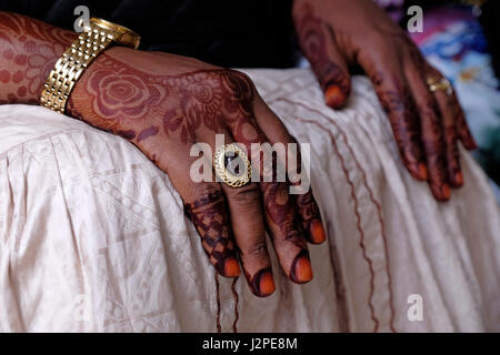 Ein kompliziertes Henna-Design auf dem Rücken und den Fingern einer Frau auf der Insel Sansibar Ostafrika. Die Designs können symbolische Bedeutungen haben, wobei verschiedene Muster Dinge wie Schönheit, Glück, Schutz oder Fruchtbarkeit darstellen. Die Dunkelheit des Henna-Flecks wird auch in einigen Kulturen als bedeutend angesehen, wobei ein dunklerer Fleck eine tiefere Liebe zwischen zwei Menschen in einer Ehe symbolisiert. Stockfoto