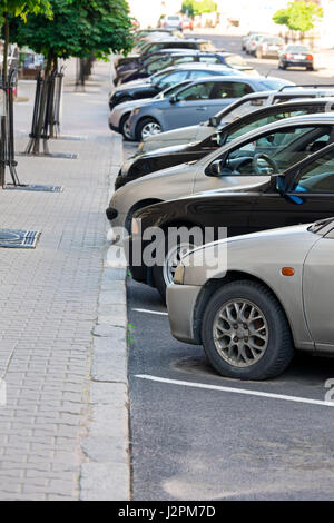 mehrere Autos schräg auf einem Parkplatz neben dem Bürgersteig geparkt Stockfoto