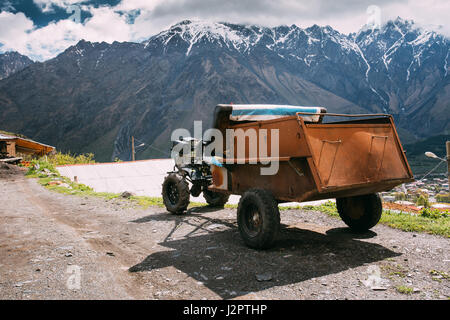 Stepantsminda zurGergeti, Georgien. Kleine alte zwei-Rad-Schlepper oder Walking Traktor Französisch mit Anhänger In einem ländlichen Haushalt verwendet. Traktor unterwegs In Villa Stockfoto