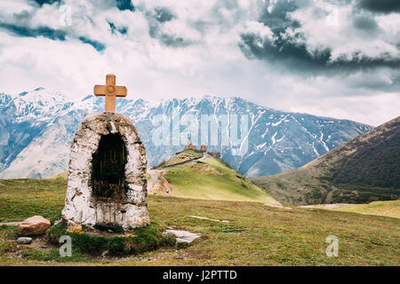 Überqueren Sie auf Steinen auf zurGergeti Dreifaltigkeitskirche oder Tsminda Sameba Hintergrund. Holy Trinity Church in der Nähe von Dorf zurGergeti In Georgien. Frühjahr oder Sommer Seaso Stockfoto