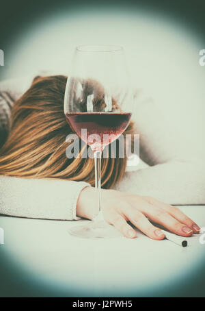 Betrunken Frau schläft auf dem Tisch. Weibliche Alkoholismus. Stockfoto