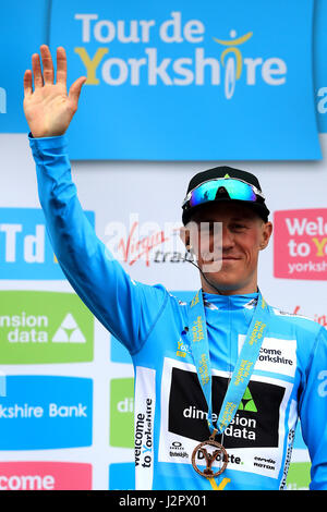 Team Dimension Data Serge Knochenstücke feiert Gesamtsieg mit dem blauen Trikot nach dem Gewinn der dritten Stufe der Tour-de-Yorkshire. Stockfoto