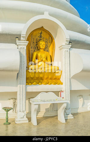 Die Statue von Lord Buddha, Lehre über die kosmische Ordnung, in der Nische des japanischen Friedenspagode auf Rumassala Berg, Unawatuna, Sri Lanka. Stockfoto