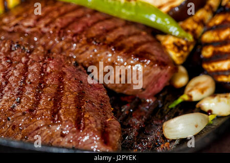 gebratenes Rindfleisch mit Auberginen, Paprika, Knoblauch auf Pfanne, Nahaufnahme Stockfoto