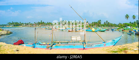 HIKKADUWA, SRI LANKA - 4. Dezember 2016: Die lange Oruwa Boot liegt im Hafen von Kumarakanda, andere voller Boote und umgeben von üppigen Wendekreises Greene Stockfoto