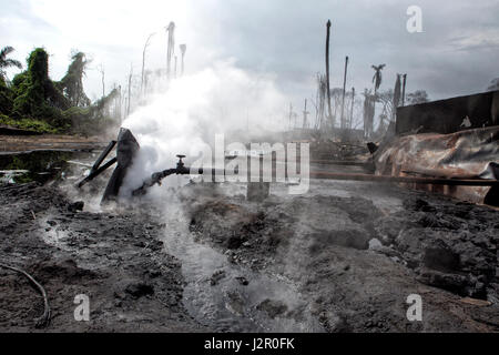 Kochend heißes Öl ist gießt in offenen Deiche zu Luft-Speicher-Pools auf dem Gelände einer illegalen Raffinerie, massive Verschmutzung, in der Nähe von Port Hartcourt, River State, Nigeria zu öffnen Stockfoto