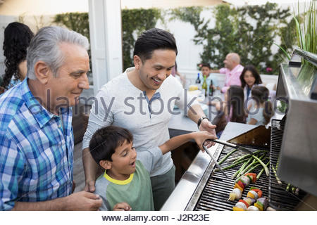 Generationsübergreifende Familie grillen, im Grill auf der Terrasse