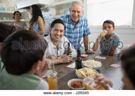 Generationsübergreifende Familie Spielkarten, Essen und trinken am Strand Haus Küchentisch