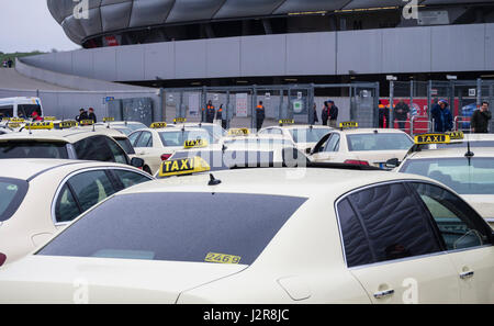 München, Deutschland - 22. April 2017: Taxis sind Warteschlangen in der Regen draußen das Fußballstadion Allianz Arena in München. Mit 75'000 Sitzplätzen, A Stockfoto