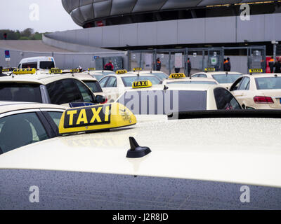 München, Deutschland - 22. April 2017: Taxis sind Warteschlangen in der Regen draußen das Fußballstadion Allianz Arena in München. Mit 75'000 Sitzplätzen, A Stockfoto