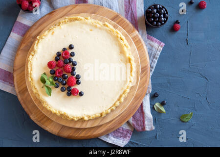 Hausgemachter Käsekuchen mit frischen Beeren und Minze zum Nachtisch - gesunde Bio Sommer Dessert Kuchen Käsekuchen. Käsekuchen. Stockfoto