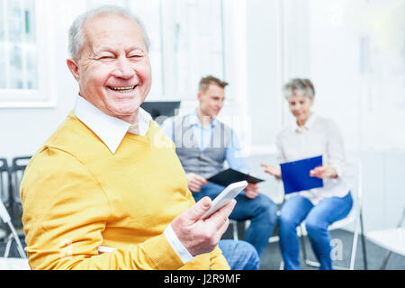 Erfolgreichen senior Mann als Berater hält Smartphone und lächelt mit Freude Stockfoto