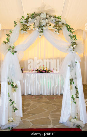 Hochzeit Bogen mit Schleier und Blumen geschmückt Stockfoto