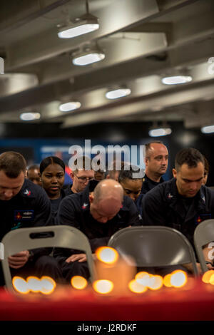 170424-N-UV609-019 arabischen Golf (24. April 2017) Segler beobachten einen Moment der Stille während einer Holocaust-Gedenkveranstaltung an Bord des Flugzeugträgers USS George H.W. Bush (CVN-77) (GHWB) statt. GHWB in den USA bereitgestellt wird 5. Flotte Bereich der Maßnahmen zur Erhöhung der Sicherheit im Seeverkehr Operationen, Verbündete und Partner zu beruhigen, und die Freiheit der Schifffahrt und den freien Fluss des Handels in der Region zu erhalten. (Foto: U.S. Navy Mass Communication Specialist 3. Klasse David Mora/freigegeben) Stockfoto