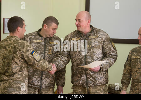 Ukrainische Oberstleutnant Pavlo Rozhko, der Kommandant der Yavoriv Combat Training Center, gratuliert ein Absolvent der Beobachter Controller Trainer Akademie während einer Zeremonie am 25 April am Yavoriv Combat Training Center auf der internationalen Friedenssicherung und Security Center in der Nähe von Yavoriv, Ukraine von ukrainischen und US Mentoren unterrichtet. (Foto von Sgt. Anthony Jones, 45. Infanterie Brigade Combat Team) Stockfoto