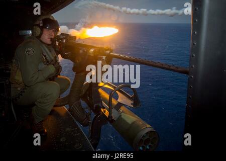 US Marine Corps Sergeant Trevor Fortune, eine Crew Chief für Marine Light Attack Helicopter Squadron - 267, starrt aus einem UH-1Y Huey, während er während einer Mission Rehearsal Übung auf Okinawa, Japan, 26. April 2017 Fackeln freigibt. Die Mission Rehearsal Übung wird durchgeführt, um verschiedene Vermögenswerte des III. Marine Expeditionary Force zu nutzen und integrieren sie als kombinierte Einheit, die Ziele des III MEF im pazifischen Raum zu erreichen. (Foto: U.S. Marine Corps MCIPAC Bekämpfung der Kamera Lance CPL Juan C. Bustos) Stockfoto