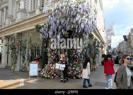 Kunstblumen mit Glyzinien grüßen Shopper am Eingang der Fenwick Kaufhaus am Brook Street und New Bond Street, London UK KATHY DEWITT Stockfoto