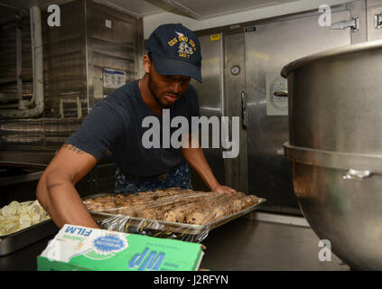 MAYPORT, Florida (27. April 2017) – kulinarische Spezialist 3. Klasse Kyheim Porter hüllt ein Tablett mit Cookie-Teig in der Backstube des amphibischen Angriff Schiff USS Iwo Jima (LHD-7) zur Vorbereitung der Mayport Navy Exchange Cupcake Kriege. Iwo Jima führt derzeit eine weitere Wartungsarbeiten Verfügbarkeit. (Foto: U.S. Navy Mass Communication Specialist 2. Klasse Hunter S. Harwell/freigegeben) Stockfoto