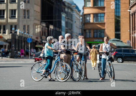 RIGA, Lettland - 14. August 2015: Gruppe von Touristen auf Fahrräder in den Straßen. Geführte Tour von einem Guide geführt. Stockfoto