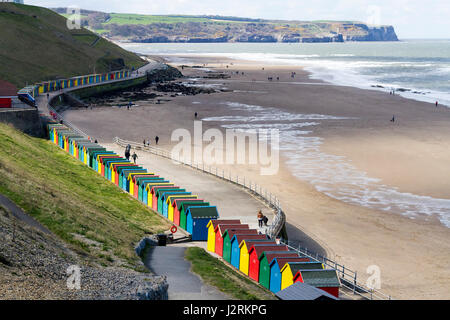 Reihe von bunten hölzernen Strandhütten entlang der Promenade West Cliff bei Whitby, North Yorkshire, England, UK Stockfoto