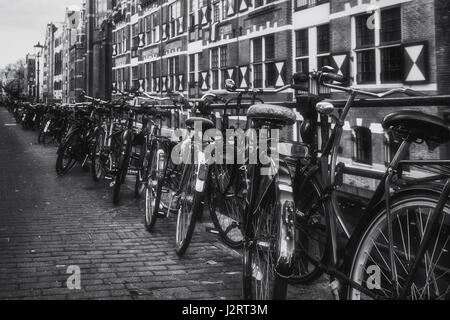 Amsterdam, Niederlande – 30. Oktober 2016: Fahrräder geparkt an die Reling des Kanals Oudezijds Kolk im Zentrum von Amsterdam. Stockfoto