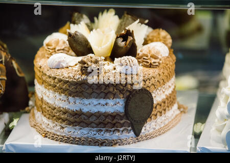 Frische süße Kuchen mit verschiedenen Pralinen In Pastry Shop-Glas-Display. Stockfoto