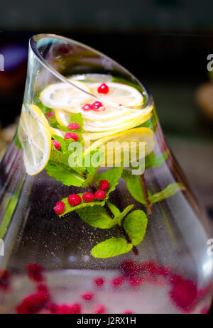 Gesunde Schönheit moderner frisches Getränk mit Cranberry Himbeere, Minze, Zitronenscheiben in großen Live mit Glaskanne Stockfoto