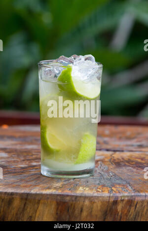 Glas Zitrone und Limette Caipirinha auf hölzernen Tisch nach dem Regen Stockfoto