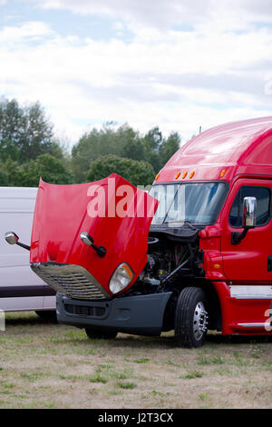 Schwere Pflicht stilvolle moderne rot big rig Semi - Truck mit einem offene Haube Zustand zu überprüfen den Motor und das Kühlsystem für den Parkplatz grasbewachsenen Stockfoto