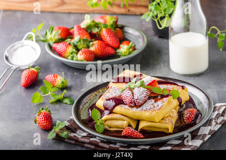 Gefüllte Pfannkuchen mit Erdbeeren, frischen Beeren und sauce Stockfoto