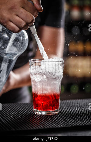 Barkeeper ist Soda Wasser gießen, er bereitet einen Himbeeren cocktail Stockfoto