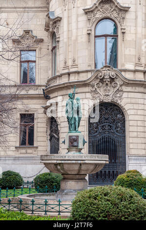 Brunnen auf dem Hintergrund der Fassade des Metropolitan Ervin Szabo-Bibliothek ist die größte Bibliothek Netzwerk in Budapest, Ungarn. Stockfoto