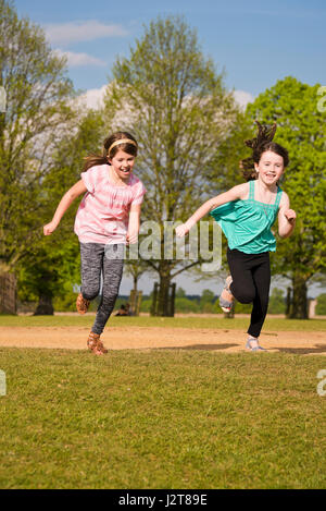 Vertikale Portrait Mädchen quer durch einen Park in der Sonne. Stockfoto