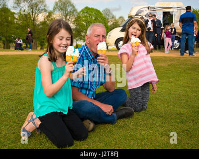 Horizontale Porträt von einem Opa Behandlung von seinen Enkeln, ein Eis im Park. Stockfoto