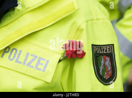 Wuppertal, Deutschland. 1. Mai 2017. Eine Polizistin trägt eine rote Nelke, das Symbol der Arbeiterbewegung, an ihrer Jacke bei einer Demonstration am Tag der Arbeit in Wuppertal, Deutschland, Mai 01. 2017. Nur zwei Wochen vor der Landtagswahl Nordrhein-Westfalen ist die Website der Mai Rallye mit mehreren Gewerkschaft Köpfe und Top-Politiker. Ihre Forderung: Es darf ein fairer Ansatz in Deutschland. Foto: Bernd Thissen/Dpa/Alamy Live News Stockfoto