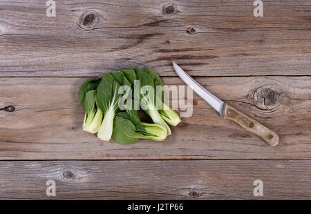 Frische chinesische Bok Choy und Schälmesser auf rustikalen Holz flach legen Format Stockfoto