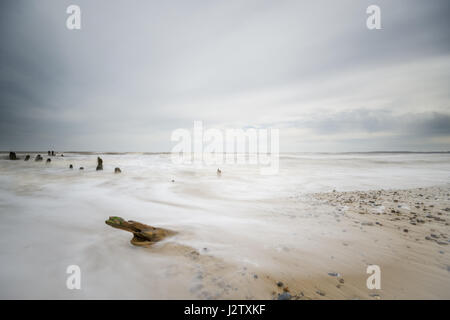 Walberswick auf die Küste von Suffolk. Beiträge Waschen im Meer am Sandstrand. Stockfoto