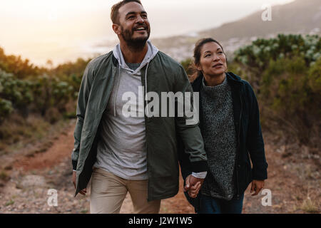 Aufnahme des jungen Mannes auf einer Wanderung mit seiner Freundin. Junges Paar Land Trail Weg zu gehen. Stockfoto