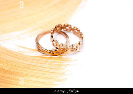 Zwei goldene Hochzeit Ringe einer abstrakten vergoldet Acryl Hintergrund Stockfoto