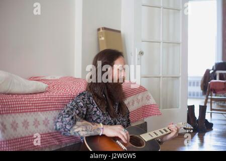 Junger Mann spielt eine akustische Gitarre Stockfoto