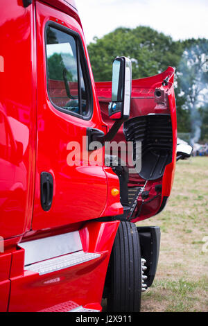 Große moderne helle rote Sattelschlepper für den professionellen gewerblichen Verkehr mit eine offene Haube auf dem Parkplatz, den technischen Zustand der En überprüfen Stockfoto