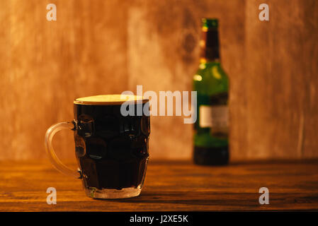 Dunkles Bier in britischen Grübchen Glas Bier Krug am Stehtisch Stockfoto