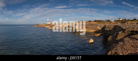 Panoramablick auf die Küste bei Portland, mit dem Portland Bill Leuchtturm in der Ferne an einem sonnigen Tag. Stockfoto