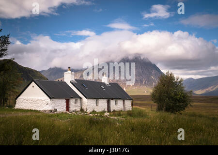 Atemberaubende Aussicht von Black Rock Cottage in den schottischen Highlands, mit Blick auf Buachaille Etive Mòr an einem sonnigen Tag mit Wolken über den Berg. Stockfoto