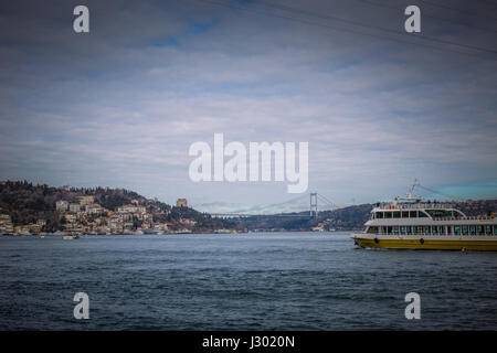 Blick auf Bosporus und Fatih Sultan Mehmet-Brücke. Mit der Fähre nähert sich die zweite Brücke am Bosporus in Istanbul, Türkei an einem bewölkten Frühlingstag. Stockfoto