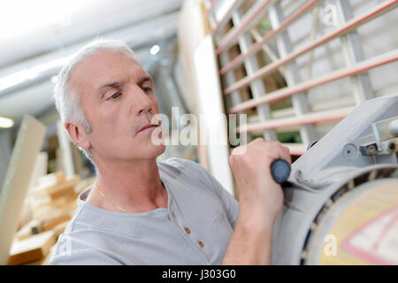 Tischler mit Hilfe einer Maschine Stockfoto